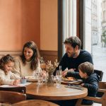 Famille avec deux enfants déjeunant dans un restaurant kids friendly chaleureux à Lyon