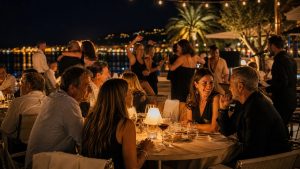 Terrasse de restaurant dansant à Toulon en soirée, avec des convives attablés et des couples qui dansent face au port illuminé.