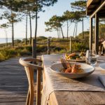 Table élégante sur la terrasse d’un restaurant à Biscarrosse, avec cuisine locale et pins maritimes en arrière-plan