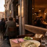 Restaurant lyonnais convivial et abordable au coucher du soleil, avec plat de quenelles, pain et terrasse dans une rue pavée.